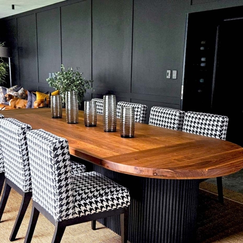 Luxury **custom furniture** suite by edge.ids featuring a solid timber dining table and **bespoke upholstery** in houndstooth fabric with coordinated **custom cushions** in a modern Johannesburg home.