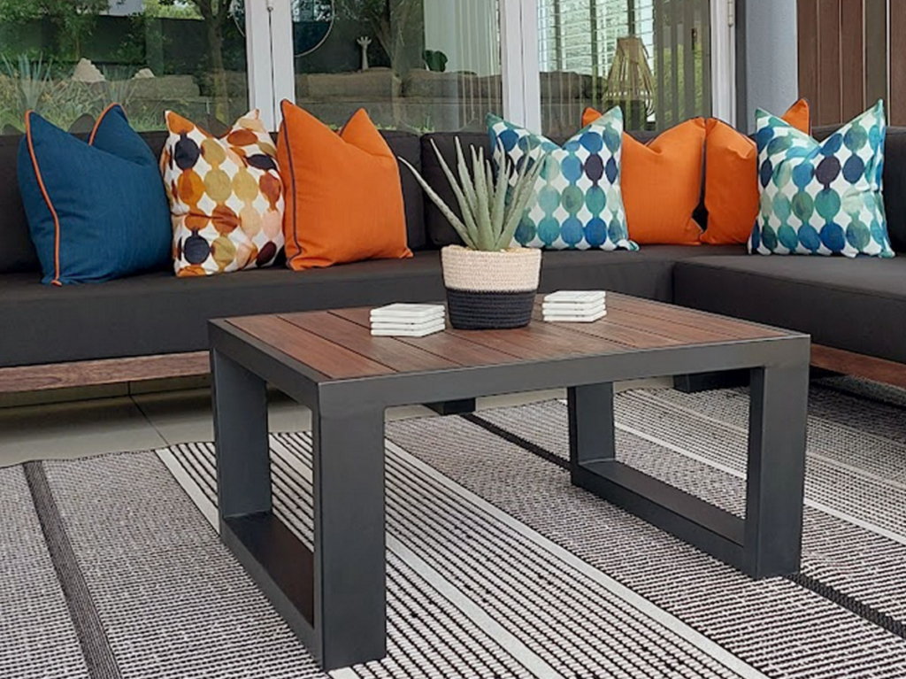 Close up view of a custom steel and timber coffee table with bespoke scatter cushions by Edge.IDS.
