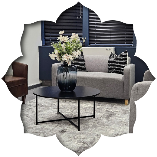 Custom-made grey office couch by Edge.IDS in a private medical suite, featuring a navy blue feature wall and minimalist black coffee table.